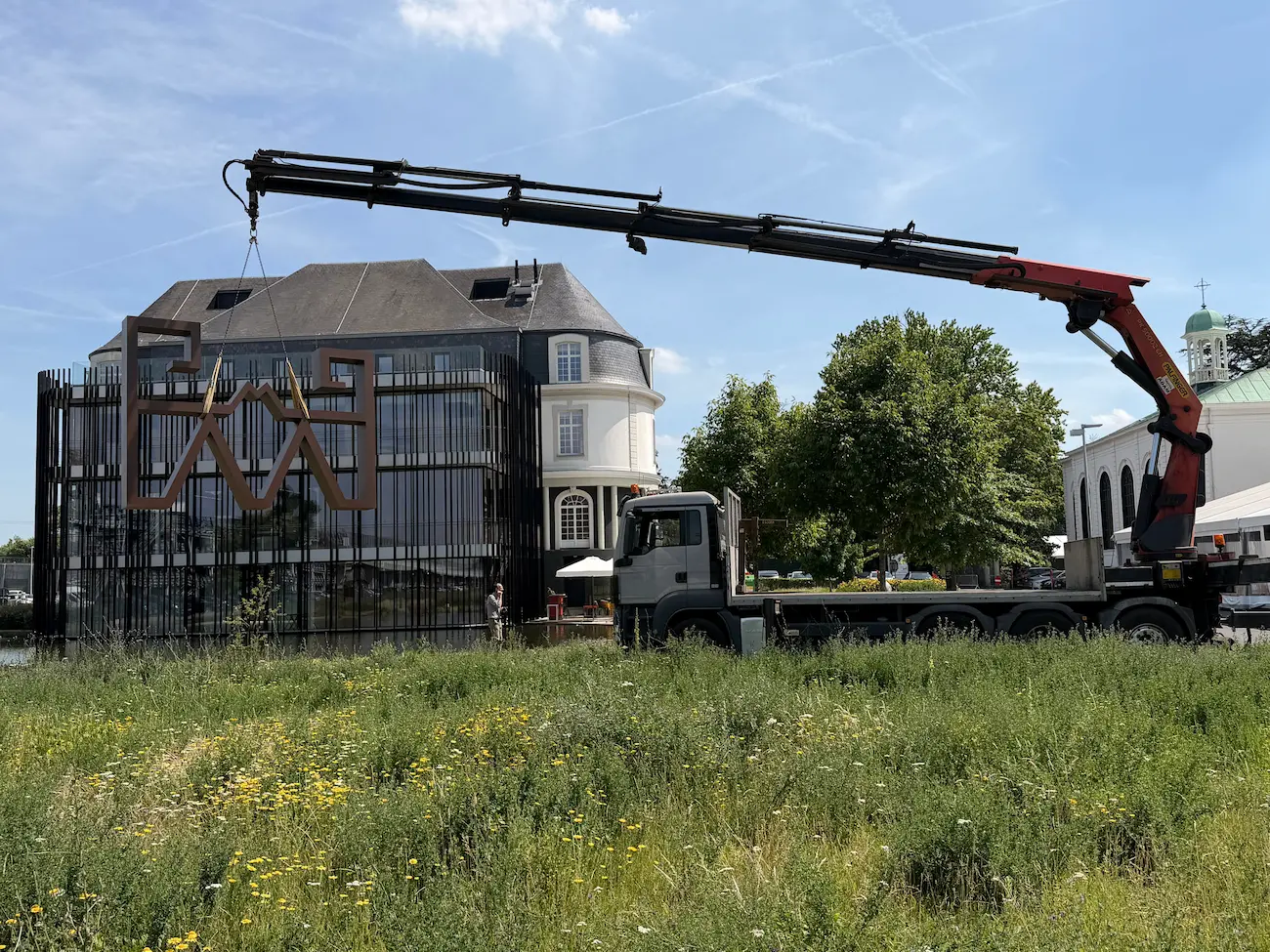 Plaatsing van een cortenstalen kunstwerk van 4 × 3,5 meter met kraan aan ziekenhuis Maria Middelares in Gent.