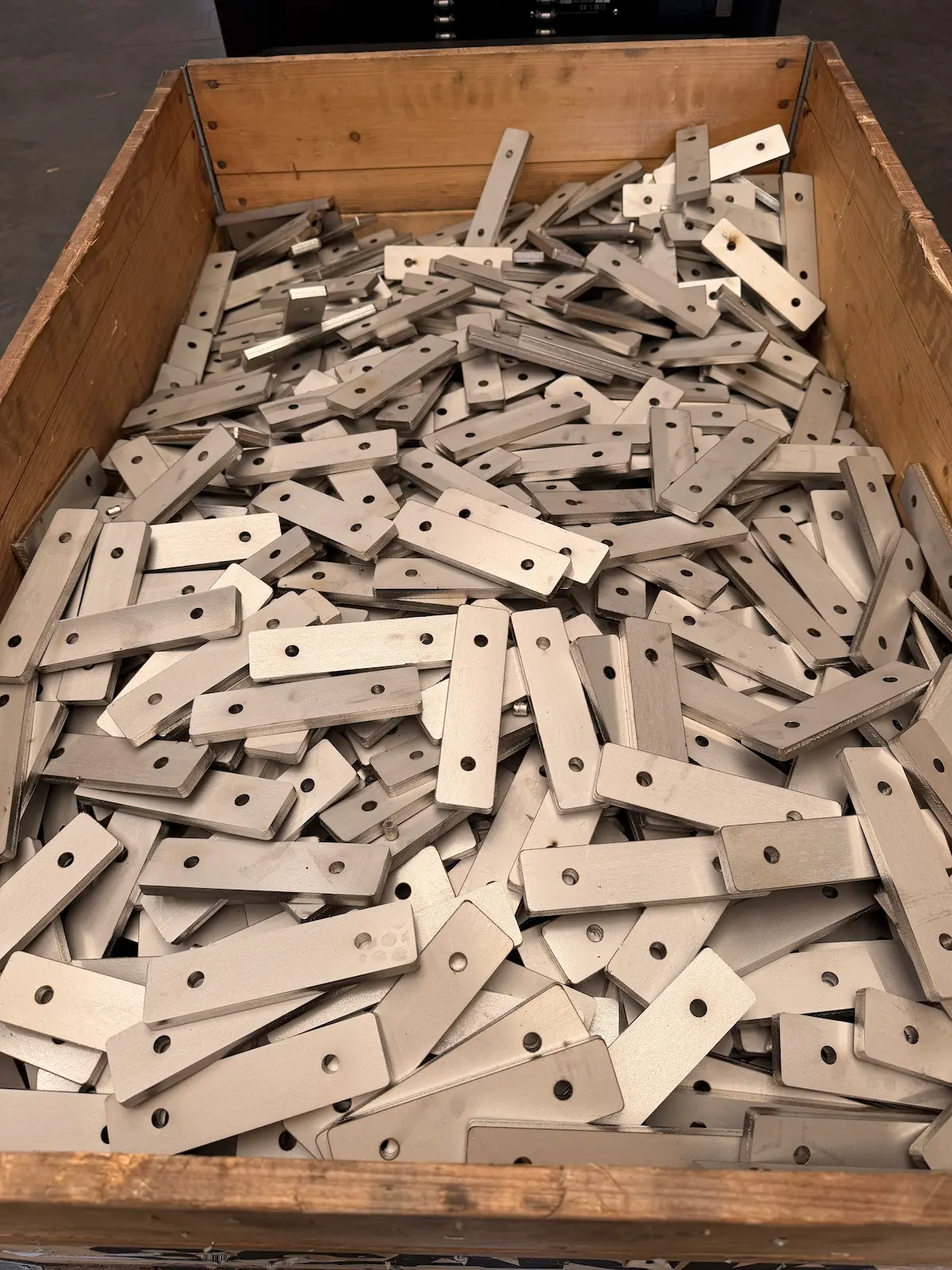 Meer dan 1000 inox stukken van 10 mm dik, net gelasersneden en in een bak